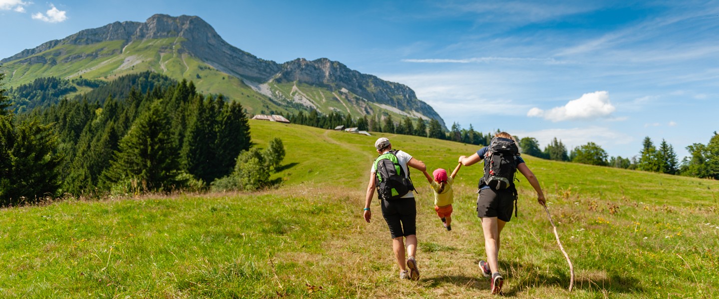 Un couple et son enfant marchant dans un paysage montagnard