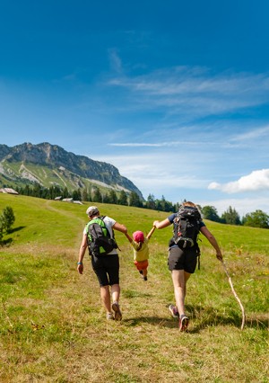 Un couple et son enfant marchant dans un paysage montagnard