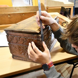 Un jeune travaillant sur un coffre ancien