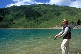 Un jeune pêcheur au bord d'un lac