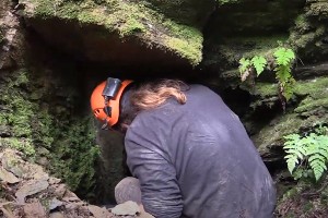 Un archéologue à l'entrée d'une mine