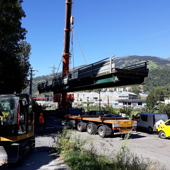 Une grue qui soulève le pont, qui arrive sur la remorque du camion