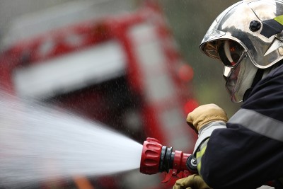 Un pompier actionne la lance à incendie