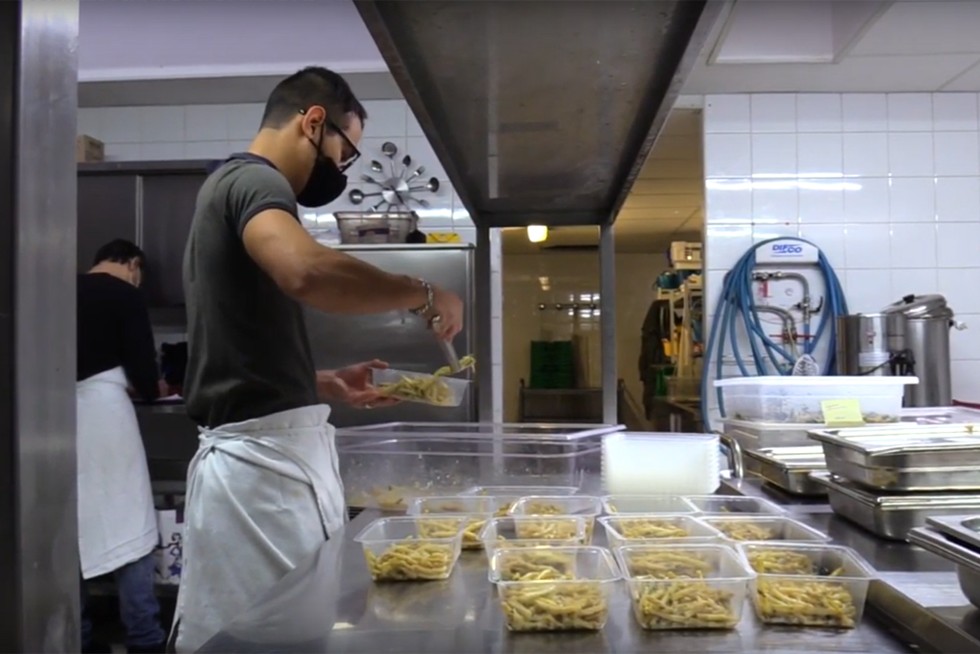 Un employé confectionne des repas