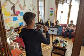 Un musicien joue du hautbois devant des très jeunes enfants et leurs parents