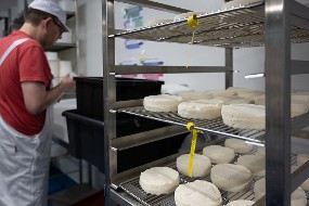 Un employé travaille le fromage