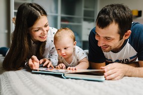 Un bébé lisant avec ses parents